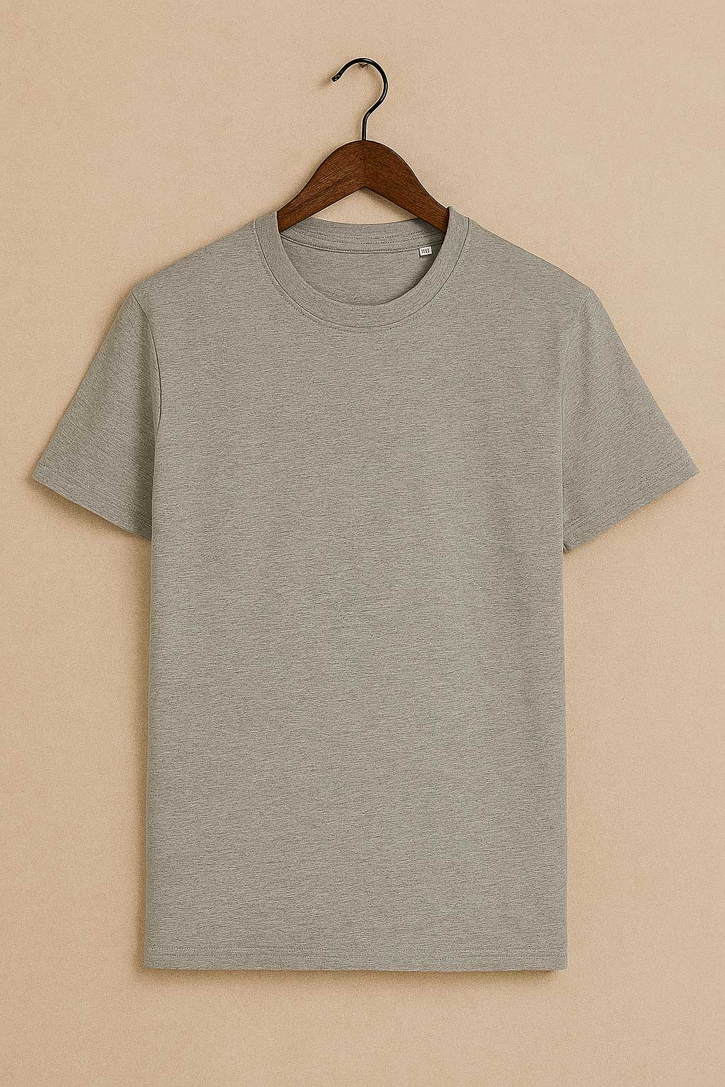 Gray t-shirt on a hanger against a beige background
