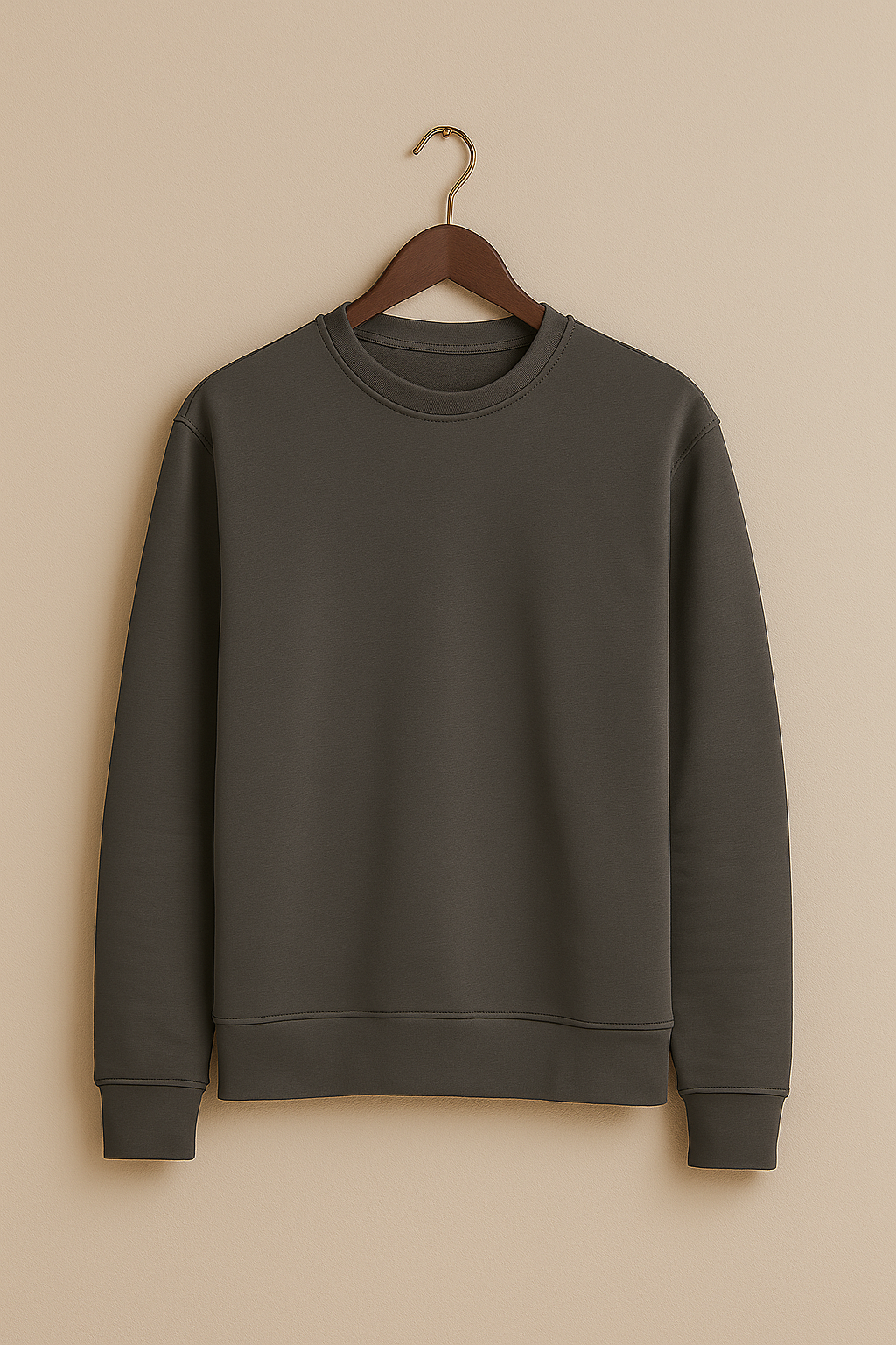 Dark gray sweatshirt on a wooden hanger against a beige background