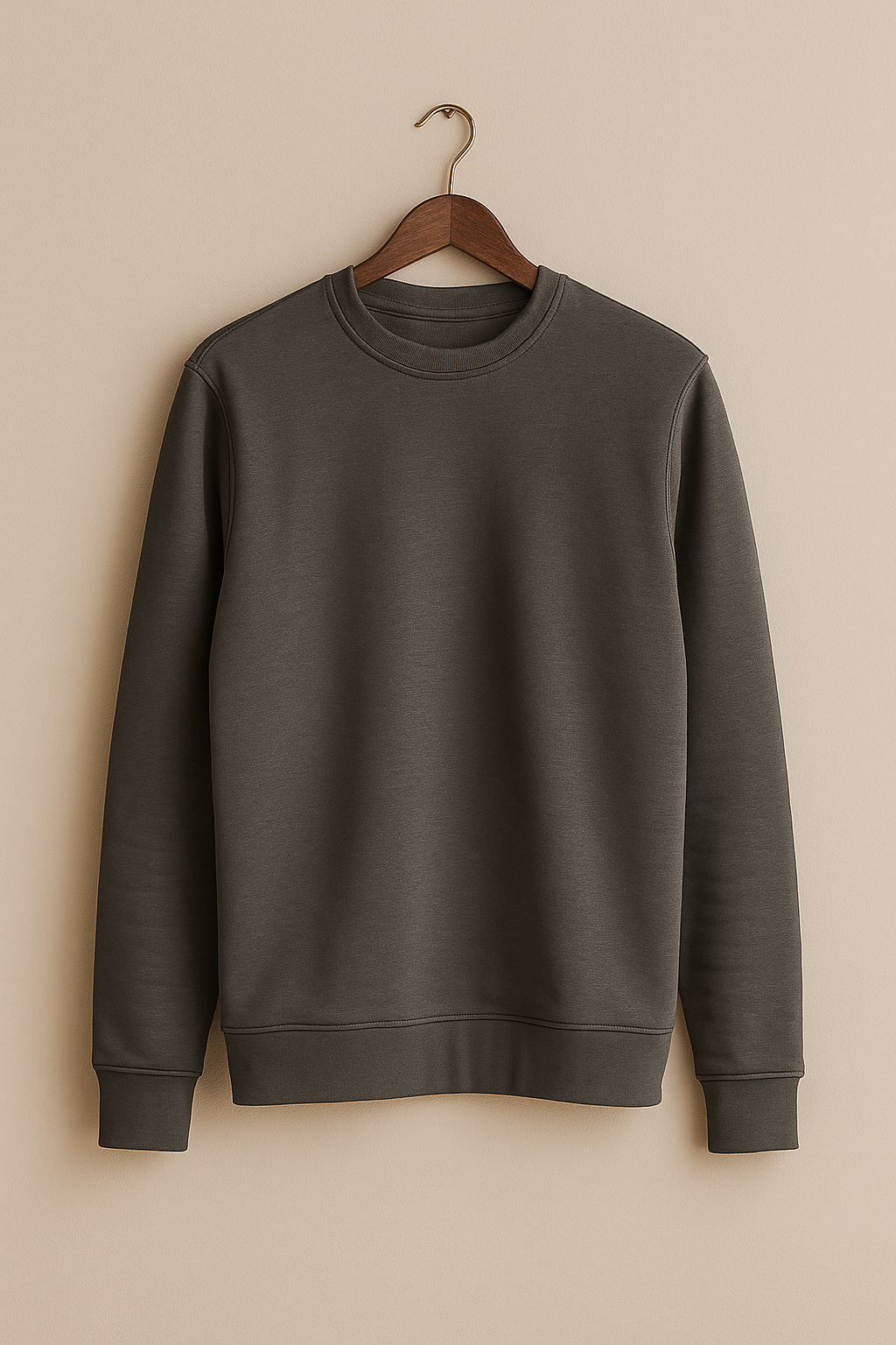 Brown sweatshirt on a wooden hanger against a beige background