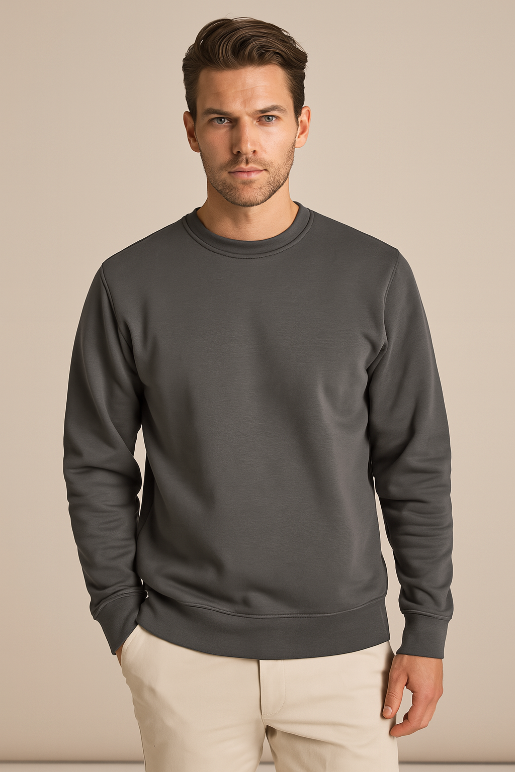 Man wearing a gray sweatshirt against a beige background